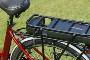 A black e-bike battery on a red bike frame.