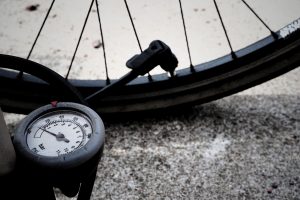 Picture of a bike tyre being pumped with a tyre pressure gauge.